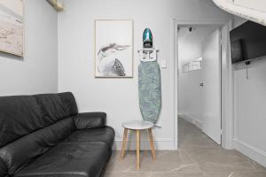a living room with a couch and a snowboard on the wall at Modern Double Room with Air Conditioning - Central CBD Location near UTS USYD Darling Harbour ICC Sydney Chinatown and Highly Rated Restaurants - Shared Bathroom in Sydney