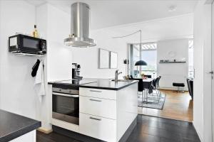 een keuken met witte kasten en een zwart aanrechtblad bij 0387-Romo-Nordre-Havnevej-18 in Havneby +20 foto's