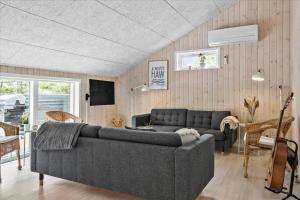 een woonkamer met een bank en een tv bij 0200-Romo-Elmegardsvej-10 in Tagholm