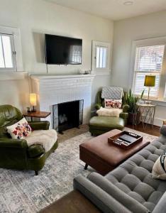 un soggiorno con divano e camino di Cozy Campus Cottage a Norman