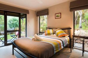 a bedroom with a bed and a balcony at Bringa - Spacious Bushland Retreat with Scenic Views in Yallingup