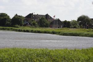 a house on the banks of a river at Hostel Rudbøl in Rudbøl