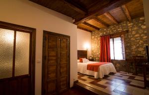 ベルモンテにあるHospedería Real Casona la Beltranejaのベッドルーム1室(ベッド1台付)、窓、ドアが備わります。