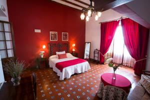 1 dormitorio con 1 cama y paredes rojas en Hospedería Real Casona la Beltraneja, en Belmonte