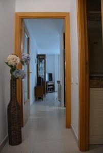 Un pasillo con un jarrón con flores. en Apartamento Flavia I Espalter, en Sitges