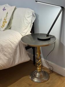 a table with a lamp on it next to a bed at Victoria House - Cozy Rooms in Edmonton
