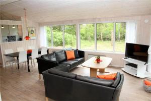 a living room with black leather furniture and a table at 0362-Romo-Skovskaden-17 in Mølby