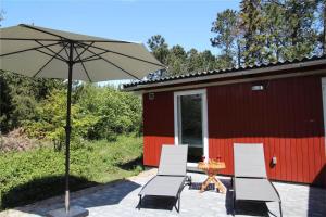 a patio with a table and chairs and an umbrella at 0362-Romo-Skovskaden-17 in Mølby