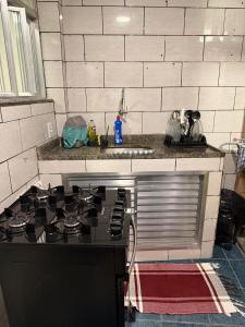 a kitchen with a stove and a sink at Hospedagem no centro da cidade! in Macaé