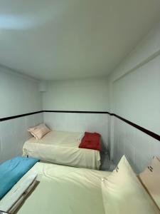 a small room with two beds in it at Hospedagem no centro da cidade! in Macaé