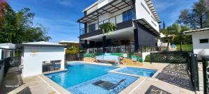 an image of a house with a swimming pool at Hotel y Cabañas Parinzzi in Guatapé