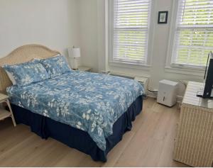 a bedroom with a bed with a blue blanket and two windows at TROPICAL Palm Beach NEW SUITE 3 Beds 2 BEDRS &2BATHROOMS ENSUITE BEACH 5 MINOutdoorPOOL Garden in Palm Beach