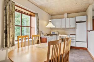 a kitchen with a table and chairs in a kitchen at 0462-Romo-Romersvej-9-Ap-2 in Rømø Kirkeby
