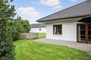 a white house with a fence and a yard at 0462-Romo-Romersvej-9-Ap-2 in Rømø Kirkeby