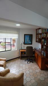 a living room with a couch and a desk and a computer at Casa Yolanda Popayán in Popayan