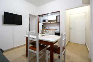 cocina con mesa con sillas y TV en Marea Patagonia, en Puerto Madryn