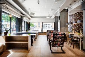 a restaurant with tables and chairs and windows at Generator Stockholm in Stockholm