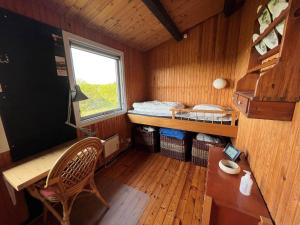 a small room with a bed and a desk and a window at 15507-Farevejle-Mimershoj-2 in Fårevejle +10 photos