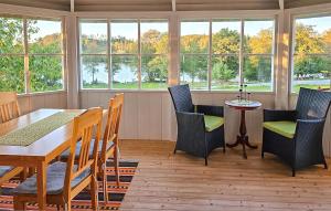 ein Esszimmer mit Tisch und Stühlen und Fenstern in der Unterkunft One-Bedroom Holiday Home In Korsberga in Korsberga