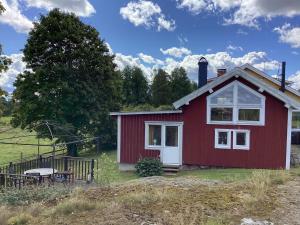 a red house with a picnic table in front of it at 4 person holiday home in UDDEVALLA in Uddevalla