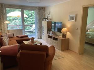 a living room with a couch and a television at Schwarzatal Trippstein 2 in Schwarzburg +9 photos