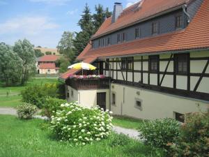 a building with a balcony with a yellow umbrella at Holiday apartment landhaus Sorgenfrei in Ehrenberg