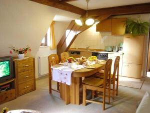 a kitchen with a table with chairs and a television at Holiday apartment landhaus Sorgenfrei in Ehrenberg