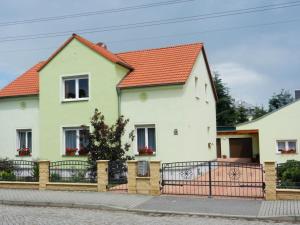 a white house with an orange roof and a fence at 2 Rehfeld family in Dresden
