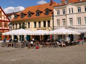 a street with tables and chairs and white umbrellas at Holiday home in Rügeband with swimming pool 