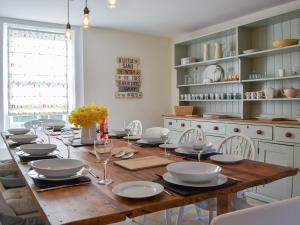 a dining room with a wooden table with plates and wine glasses at West House Farm in Filey