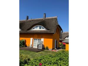 an orange house with a gambrel roof at Holiday home in Prerow with swimming pool in Prerow