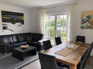 a living room with a table and a couch at Holiday home in Prerow with swimming pool in Prerow