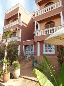 una casa grande con balcones y plantas delante de ella en Villa Sunset B&B, en Aourir