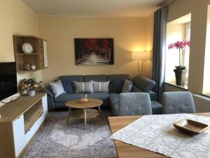 a living room with a blue couch and a table at Schwarzatal meadow view in Schwarzburg
