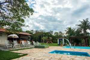 a backyard with a pool and a playground at Pousada Chão da Serra in Serra do Cipo