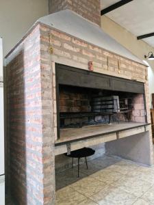 a brick fireplace with a table in front of it at Hospedaje Patagonia Sur in Gobernador Gregores