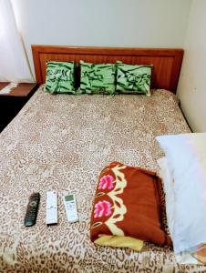a bed with two remotes and two remote controls on it at Athenas empreendimentos in Campo Grande