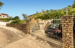 a fence with a car parked next to a house at Nice Apartment In Karlobag With Wifi in Karlobag +15 photos