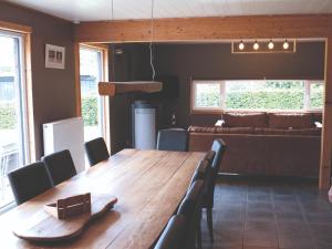 a dining room with a wooden table and a couch at High Fens Nature & Sauna Stay in Ovifat