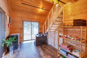 a room with wooden walls and a staircase in a cabin at Almin Base 全室プライベートサウナ付きの宿 in Minami Alps