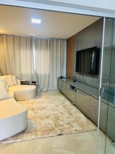 a living room with a couch and a flat screen tv at Penthouse with a privileged view in Governador Valadares +27 photos