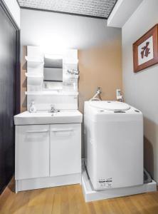 ein weißes Badezimmer mit einem Waschbecken und einem Kühlschrank in der Unterkunft Kyoto - House - Vacation STAY 13833 in Kyoto