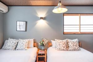 ein Schlafzimmer mit zwei Betten und einem Fenster in der Unterkunft Kyoto - House - Vacation STAY 13833 in Kyoto
