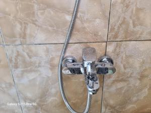 a shower with a hose attached to a tiled wall at Puri Ma'u Beach & Bungalows in Boba +57 photos