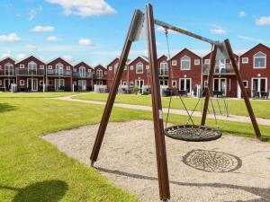 a swing set in a park with houses in the background at 6 person holiday home in Hadsund-By Traum in Hadsund