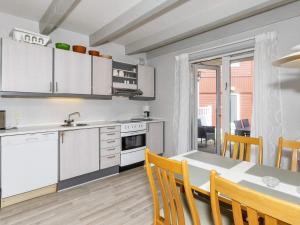 a kitchen with white cabinets and a table with chairs at 6 person holiday home in Hadsund-By Traum in Hadsund +9 photos
