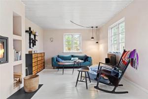 a living room with a blue couch and a chair at 15505-Farevejle-Tjornebakken-9 in Fårevejle