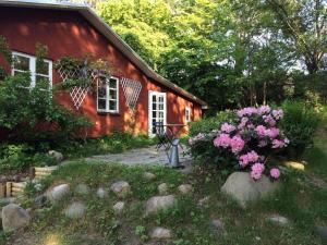 a red house with pink flowers in front of it at 15505-Farevejle-Tjornebakken-9 in Fårevejle