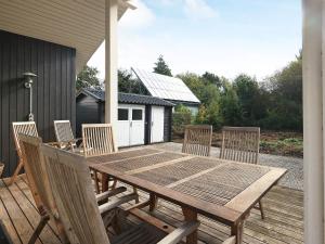 a wooden table and chairs on a deck at 8 person holiday home in Frørup-By Traum in Frørup