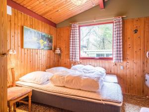 a bed in a wooden room with a window at 4 person holiday home in Nørre Nebel in Nørre Nebel